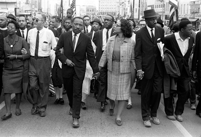 Dr. Martin Luther King, Jr. arrives in Montgomery, AL on March 25, 1965 at the culmination of the Selma-to-Montgomery march. Pictured from left, Ralph Bunche, Dr. Martin Luther King, Jr., Coretta Scott King, Rev. Fred Shuttlesworth, Hosea Williams. Photo by Morton Broffman/Getty Images, 1965.